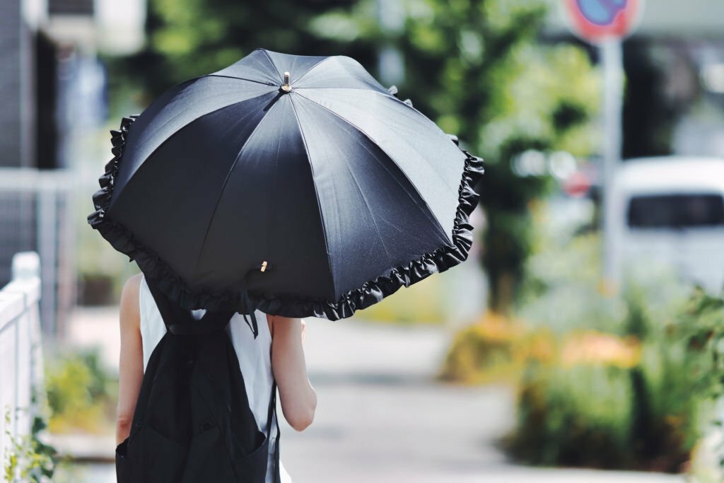 Woman holding a black parasol for uv rays protection